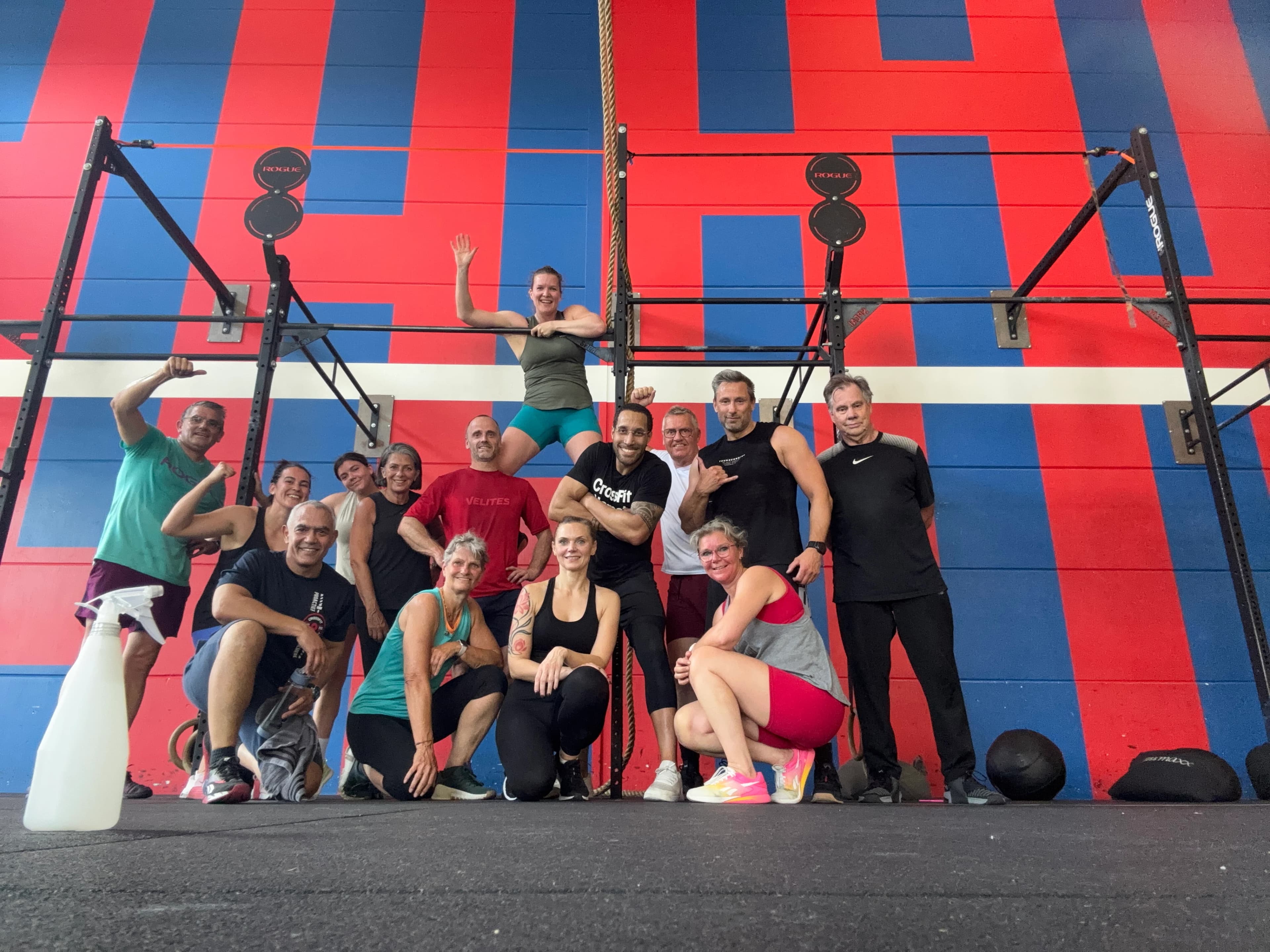 Een groep sporters poseert samen bij het rek na het trainen.
